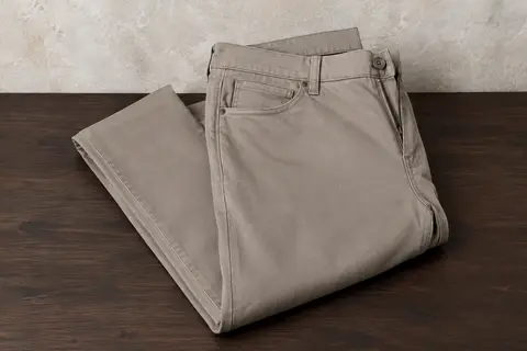 Pantalon chino homme GINGTTO à coupe ajustée, plié sur une surface en bois avec quatre poches visibles