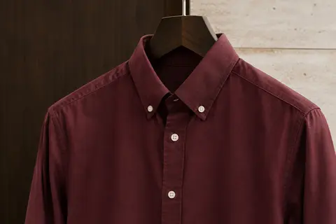 Chemise homme à coupe slim et manches longues, suspendue sur un cintre dans un décor épuré.