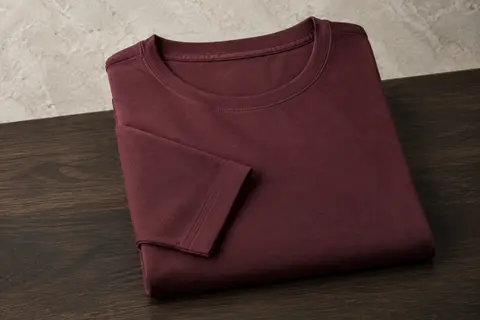 T-shirt homme en coton à manches longues et col rond, plié seul sur une surface en bois.